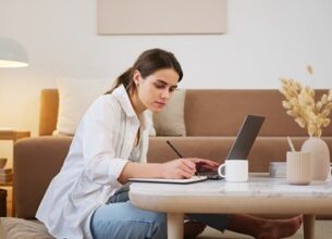 girl sitting at coffee table working on her laptop