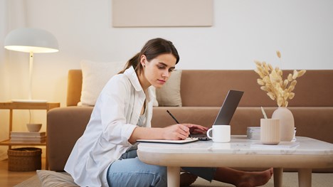 girl sitting at coffee table working on her laptop